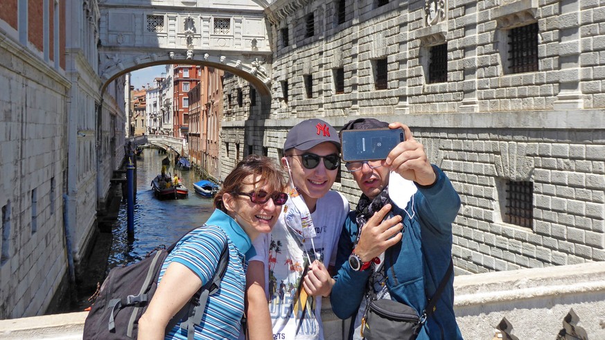 epa08458187 Tourists take a selfie with the background of the Ponte dei Sospiri, on San Marco pier in Venice, Italy, 01 June 2020. In Veneto state, the obligation to wear face masks on the street has  ...