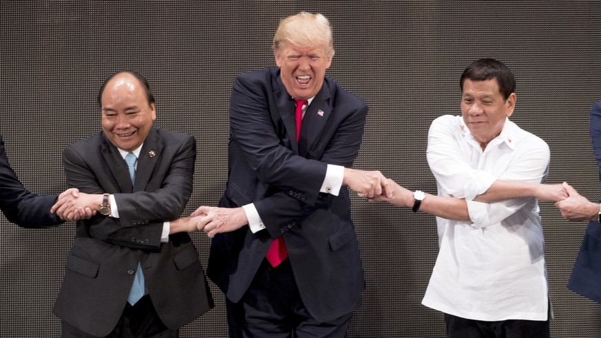 CORRECTS ID TO VIETNAMESE PRIME MINISTER NGUYEN XUAN PHUC - U.S. President Donald Trump, center, reacts as he does the &quot;ASEAN-way handshake&quot; with Vietnamese Prime Minister Nguyen Xuan Phuc,  ...