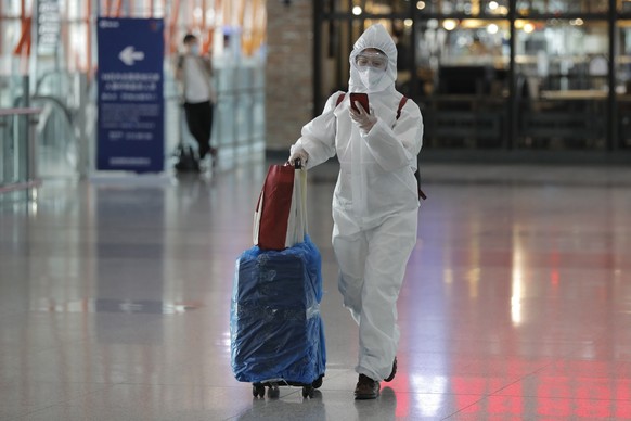 epa08354258 Passenger wearing protective suit and mask arrives at terminal 3 of Beijing Capital International Airport in Beijing, China, 09 April 2020 (issued 10 April 2020). EPA/WU HONG