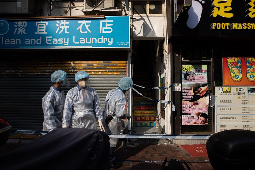epa08959115 Civil servants in protective face masks and gowns enforce a lockdown in Jordan, Hong Kong, China, 23 January 2021. The Hong Kong government placed around 10,000 residents in an estimated 2 ...