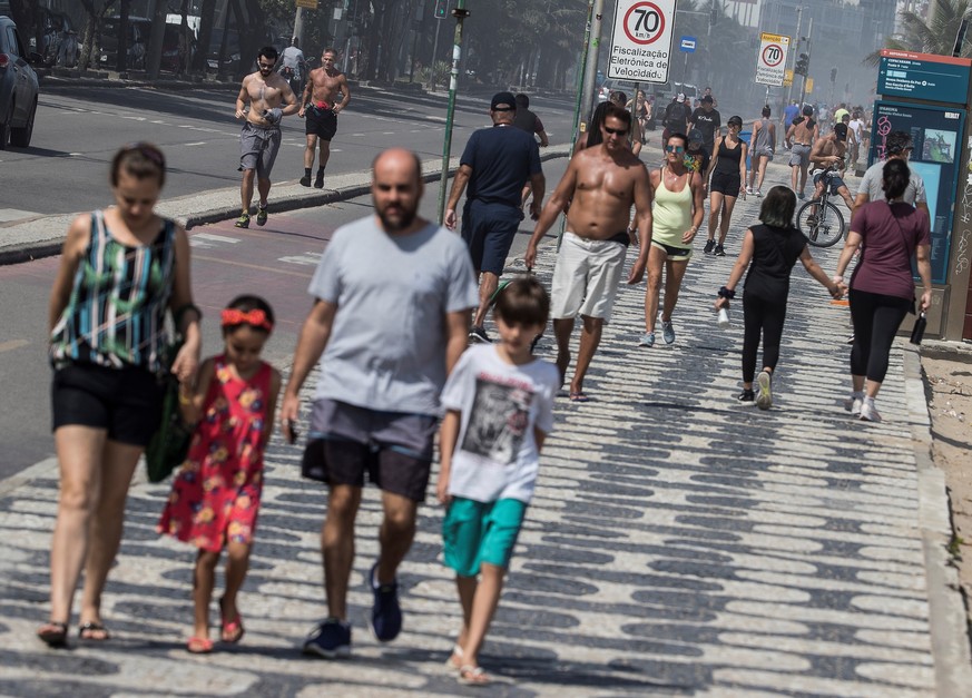 epa08344666 Hundreds of people ride their bikes and walk in the path near to the Copacabana and Ipanema beaches in Rio de Janeiro, Brazil, 05 April 2020. Despite repeated calls from the authorities fo ...
