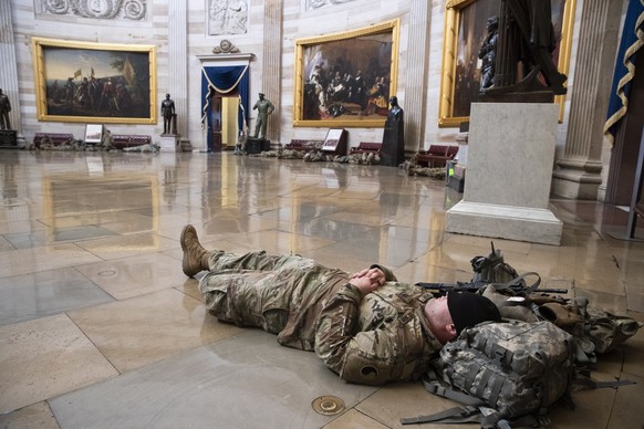 epa08935079 US National Guard troops rest in the Capitol Rotunda on Capitol Hill in Washington, DC, USA, 13 January 2021. At least ten thousand troops of the National Guard will be deployed in Washing ...