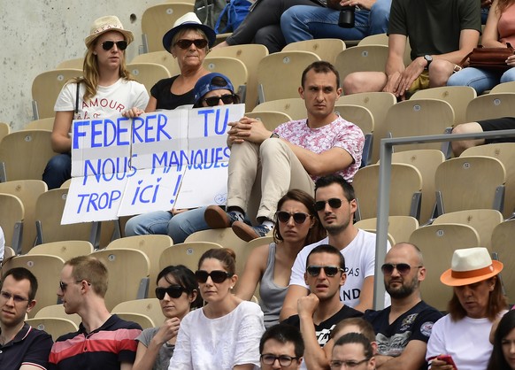 epa06784464 Spectators at court Suzanne Lenglen hold a placard that reads: &quot;Federer we are missing you a lot here&quot;, as they watch Kevin Anderson of South Africa playing Diego Schwartzman of  ...