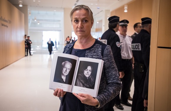epa07863774 French pulmonologist Irene Frachon poses with a book of Mediator victims&#039; portraits during the opening day of the &#039;Mediator&#039; trial at the Paris courthouse in Paris, France,  ...