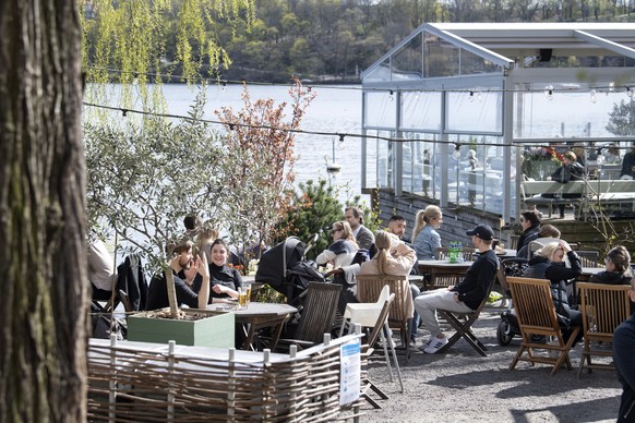 epa08385439 People enjoy the spring weather at an outdoor restaurant in Stockholm, Sweden, 26 April 2020. While many countries in Europe have instituted a lockdown in a bid to slow down the spread of  ...