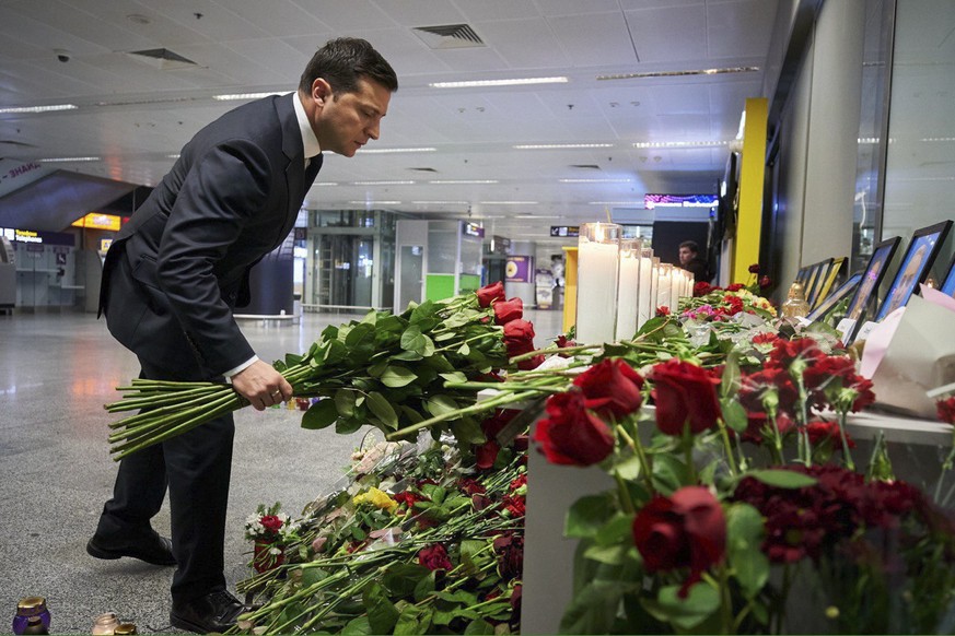 epa08113829 A handout photo made available by Ukranian Presidential Press service shows Ukrainian President Volodymyr Zelensky lays flowers to the portraits of crew members of the Ukraine Internationa ...