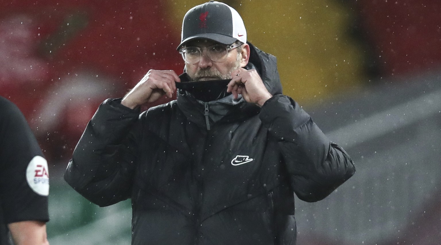 Liverpool&#039;s manager Jurgen Klopp fixes his protective mask during the English Premier League soccer match between Liverpool and Brighton at Anfield stadium, in Liverpool, England, Wednesday, Feb. ...
