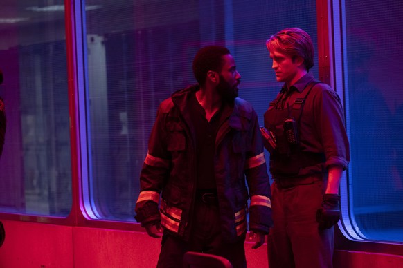 This image released by Warner Bros. Entertainment shows Robert Pattinson, right, and John David Washington in a scene from &quot;Tenet.&quot; Warner Bros. says it is delaying the release of Christophe ...