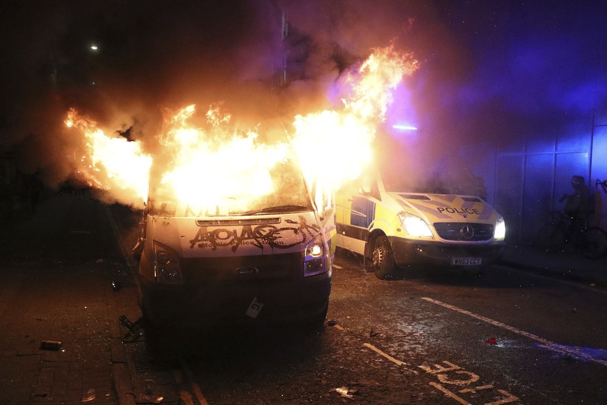 A vandalised police van on fire outside Bridewell Police Station, in Bristol, England, Sunday March 21, 2021, as people took part in a protest demonstrating against the Police and Crime Bill. (Andrew  ...