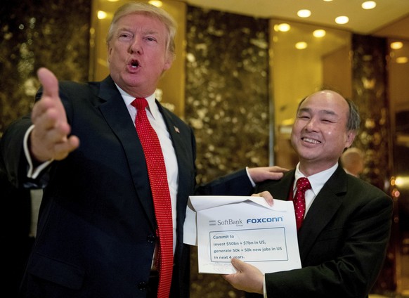FILE - In this Tuesday, Dec. 6, 2016, file photo, President-elect Donald Trump, left, accompanied by SoftBank CEO Masayoshi Son, speaks to members of the media at Trump Tower in New York. Trump talked ...