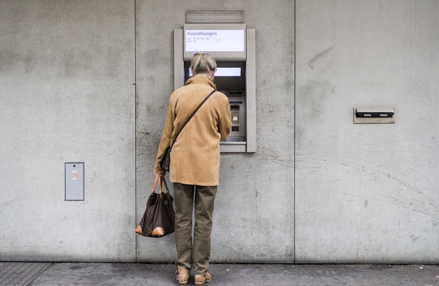 ARCHIVBILD ZUR PRAESENTATION DER RENTENREFORM DURCH DEN BUNDESRAT, AM DONNERSTAG, 28. JUNI 2018 - An elderly woman withdraws money from a cash dispenser, photographed in Zurich, Switzerland, on Septem ...