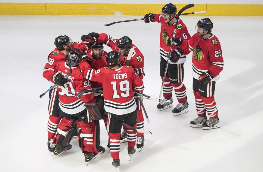 Chicago Blackhawks players celebrate their win over the Edmonton Oilers in an NHL hockey playoff game Friday, Aug. 7, 2020, in Edmonton, Alberta. (Jason Franson/Canadian Press via AP)
