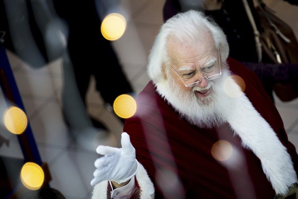 In this Sunday, Nov. 20, 2016, photo, Santa Claus waves to mall shoppers as he makes his way to the &quot;Adventure to Santa,&quot; a DreamWorks DreamPlace experience at North Point Mall, in Alpharett ...