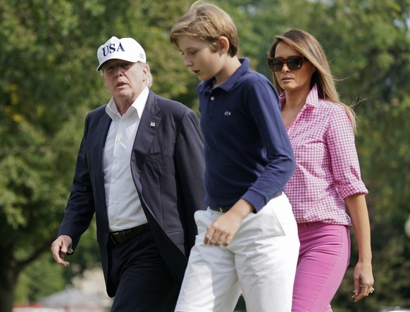 President Donald Trump, first lady Melania Trump and their son Barron Trump, 11, walk across the South Lawn of the White House in Washington, Sunday, Aug. 27, 2017, following their return after spendi ...