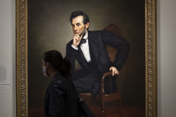 epa08679396 A person walks by a portrait of the sixteenth US President, Abraham Lincoln, by artist George Peter Alexander Healy; in the exhibit &#039;America&#039;s Presidents&#039; at the National Po ...