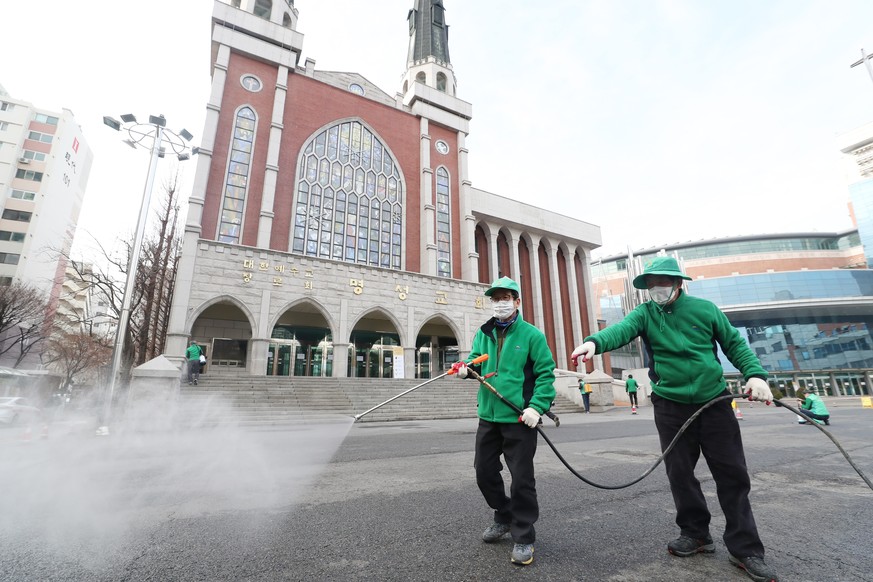 epa08248101 Workers disinfect the area surrounding Myungsung Church after a priest tested positive for COVID-19, in Seoul, South Korea, 26 February 2020. South Korea has so far reported over 1,000 cas ...