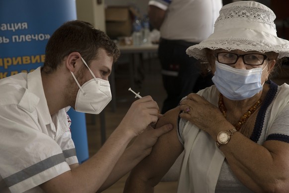 An Israeli woman receives a third coronavirus vaccine injection at a senior center in Jerusalem, Wednesday, Aug. 4, 2021. Israeli health authorities began administering coronavirus booster shots last  ...