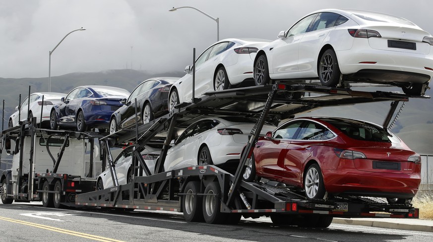 A truck loaded with Tesla cars departs the Tesla plant Tuesday, May 12, 2020, in Fremont, Calif. Tesla CEO Elon Musk has emerged as a champion of defying stay-home orders intended to stop the coronavi ...