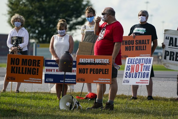 Anti-death penalty protestors gather across the street from the federal prison complex in Terre Haute, Ind., Wednesday, Aug. 26, 2020. Lezmond Mitchell, the only Native American on federal death row,  ...
