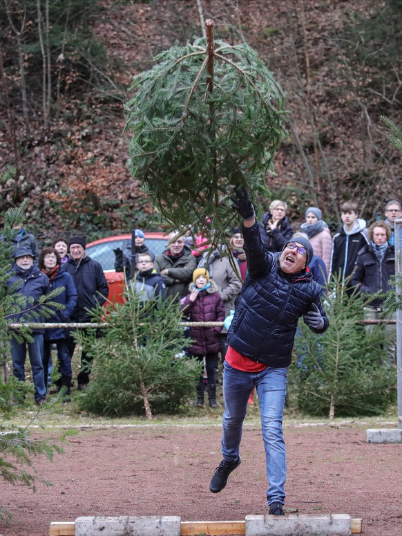 epa08104875 A participant throws a Christmas tree during the Triathlon World Championships of Christmas tree throwing in Weidenthal, Germany, 05 January 2020. The event takes place for the 18th time.  ...
