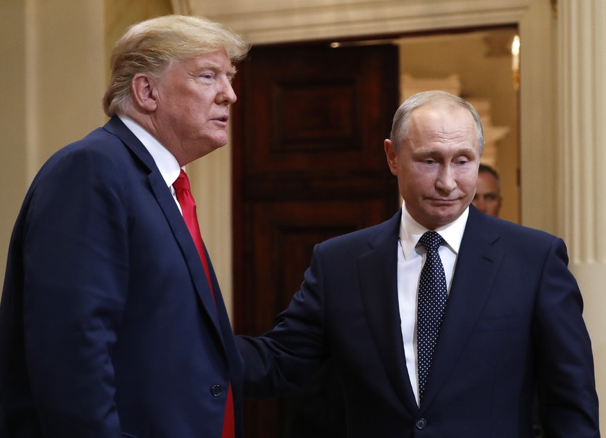 U.S. President Donald Trump, left, and Russian President Vladimir Putin leave a press conference after their meeting at the Presidential Palace in Helsinki, Finland, Monday, July 16, 2018. (AP Photo/P ...