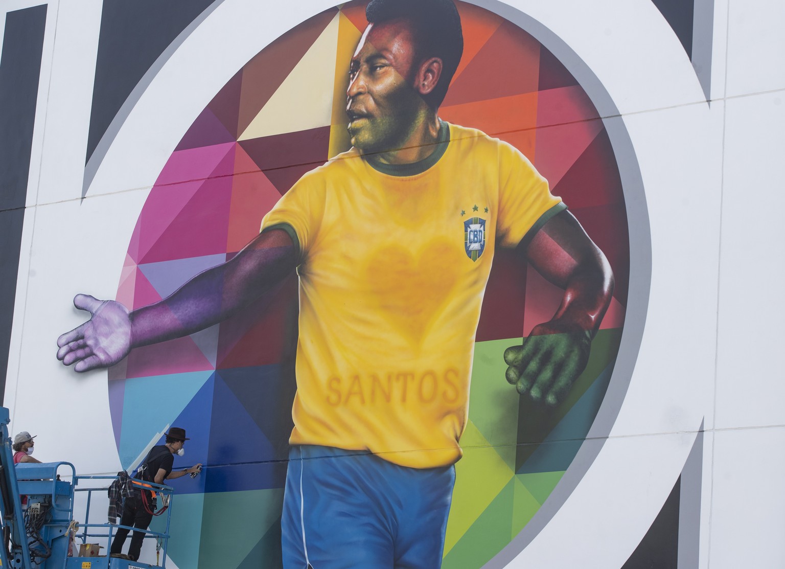 Brazilian street artist Eduardo Kobra spray paints the finishing touches to his mural to pay homage to soccer legend Pele to mark his 80th birthday in the coastal city of Santos, Brazil, Sunday, Oct.  ...