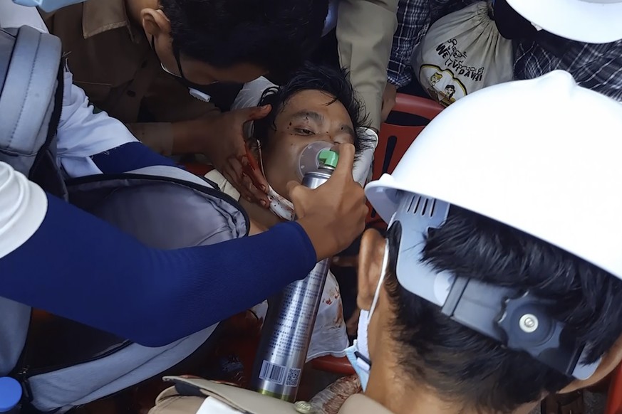 In this image from a video, medics attend to a man in a street in Dawei, Myanmar Sunday, Feb. 28, 2021. The man appeared to be a wound in his upper chest. Medics held an oxygen mask to his face while  ...