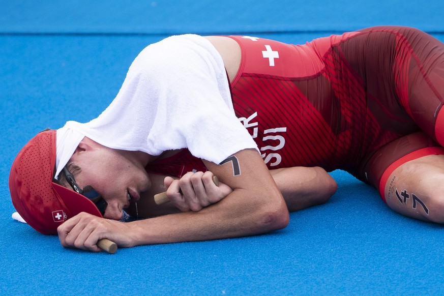 epa09365643 Switzerland&#039;s Max Studer is exhausted in the finish area during the men&#039;s Individual Triathlon competition at the 2020 Tokyo Summer Olympics in Tokyo, Japan, 26 July 2021. EPA/PE ...