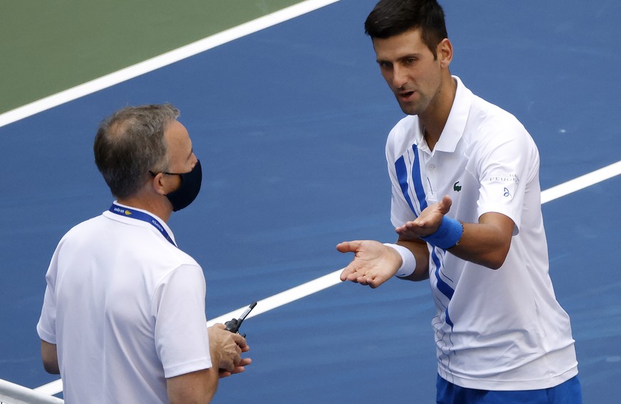 epa08651695 Novak Djokovic of Serbia (R) talks to Head of Officiating at International Tennis Federation (ITF) Soeren Friemel after he accidentally hit a linesperson with a ball in the throat during h ...