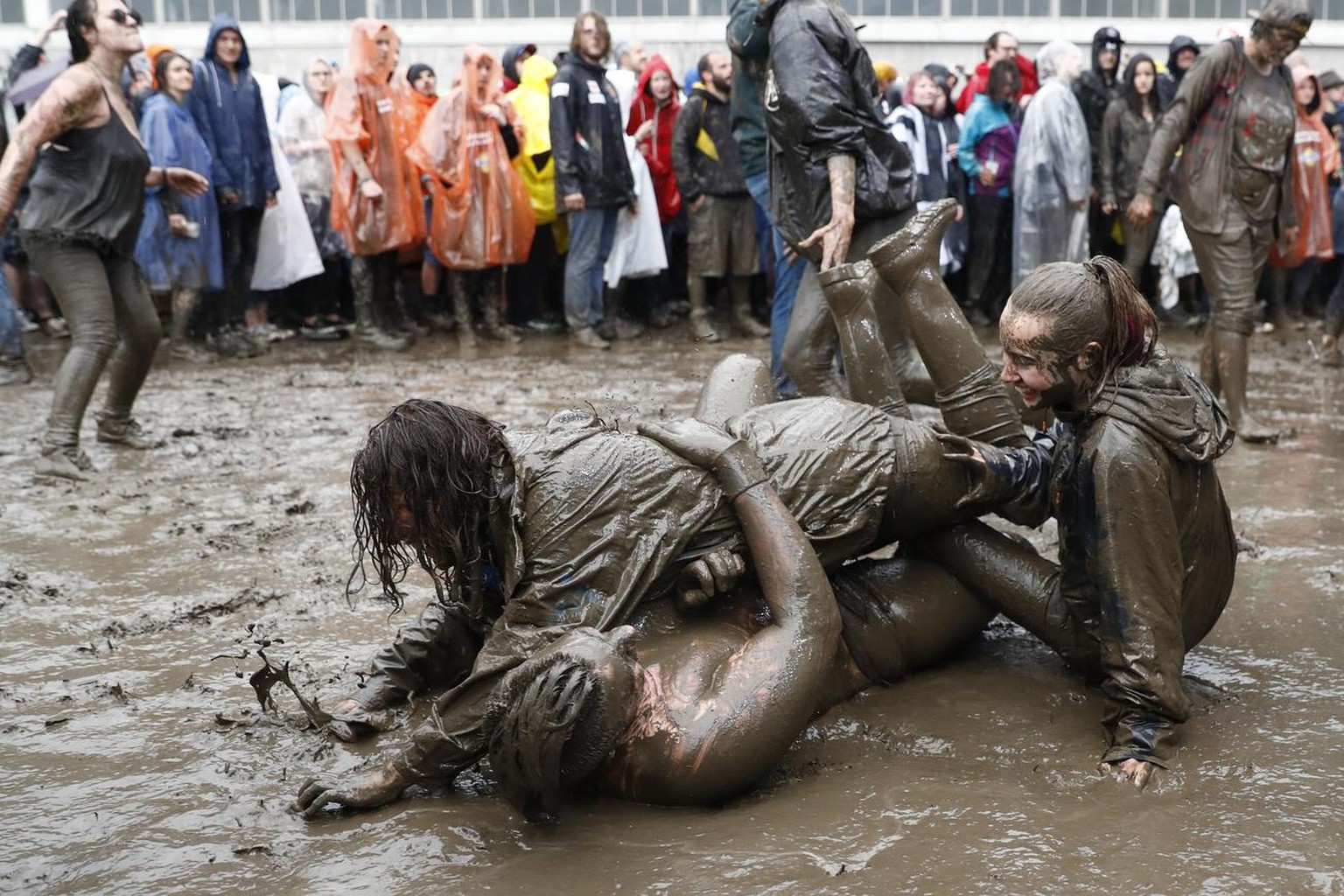 Rock fans dive in the mud at the Greenfield Openair, Wednesday, June 8, 2016, in Interlaken, Switzerland. The openair music event runs from 8 to 11 June. (KEYSTONE/Peter Klaunzer)