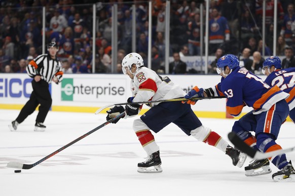 New York Islanders center Mathew Barzal (13) uses his stick to slow Florida Panthers center Denis Malgin (62) during the third period of an NHL hockey game Saturday, Oct. 12, 2019, in Uniondale, N.Y.  ...