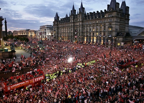 Surrounded by hundreds of thousands of fans, Liverpool players atop a bus, bottom left, celebrate their Champions League title in central Liverpool, England, Thursday May 26, 2005. Liverpool won the C ...