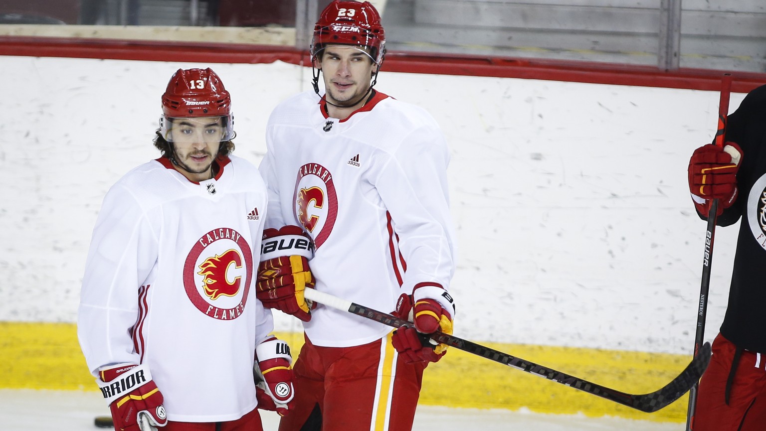 Calgary Flames&#039; Johnny Gaudreau, left, and Sean Monahan look on during a training camp practice in Calgary, Sunday, Jan. 10, 2021. (Jeff McIntosh/The Canadian Press via AP)