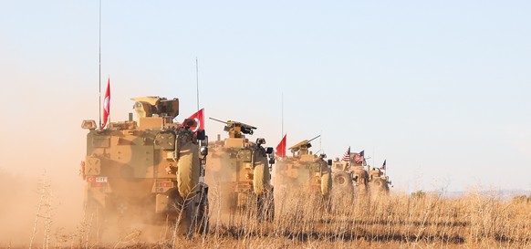 epa07252596 (FILE) - A handout photo made available by the US Army shows US and Turkish soldiers conducting the first-ever combined joint patrol outside Manbij, Syria, 01 November 2018 (reissued 29 De ...