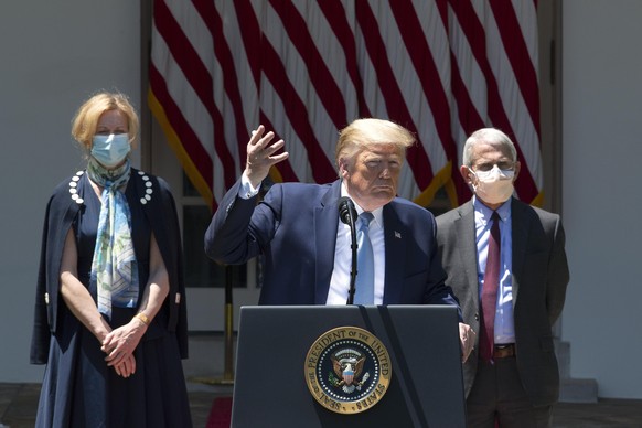 epa08424695 US President Donald J. Trump gestures for a reporter to speak louder while taking questions during a press conference regarding Coronavirus vaccine developments in the Rose Garden of the W ...