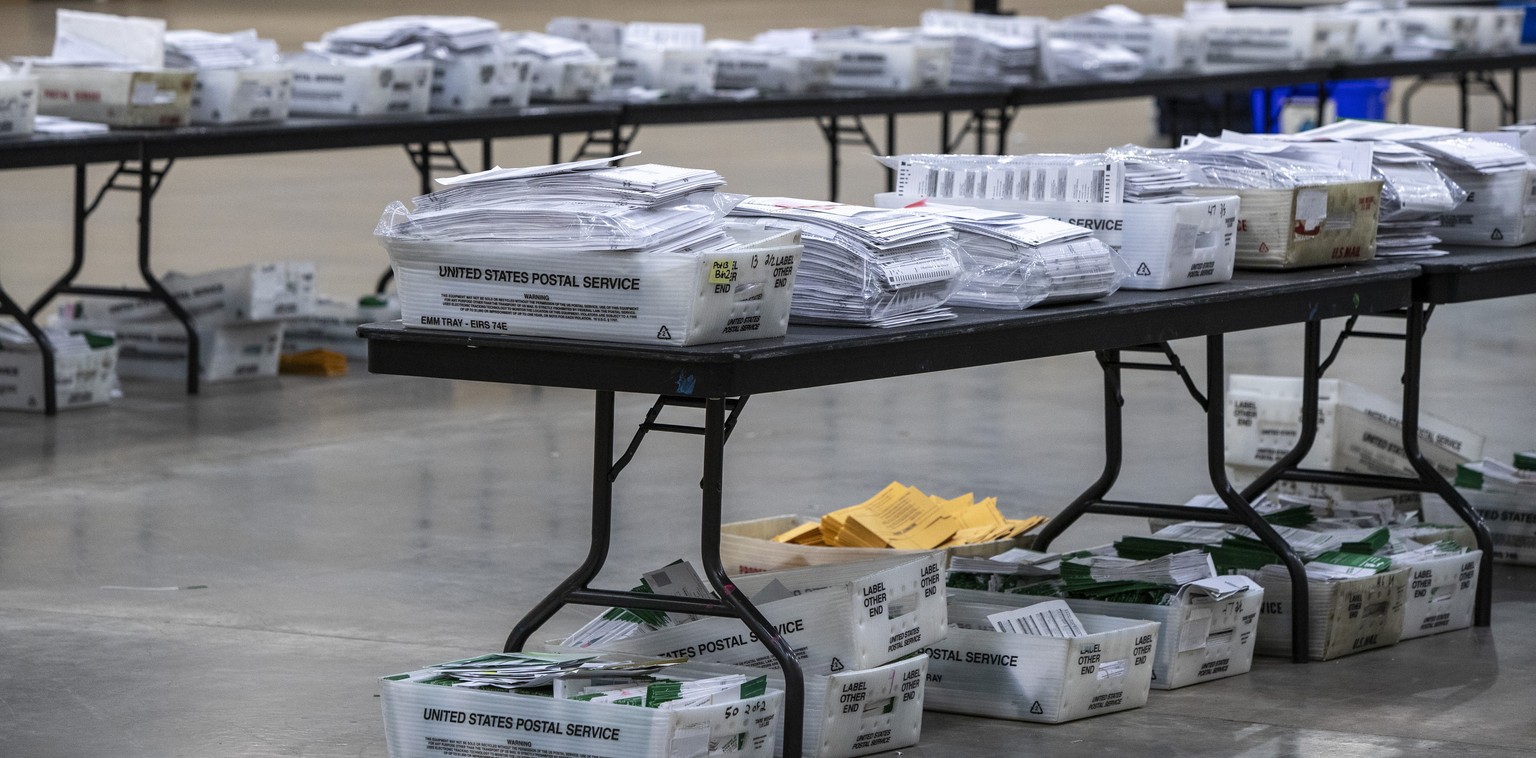 Bins and bundles of absentee ballots sit on and under tables at DeVos Place on Wednesday, Nov. 4, 2020, in Grand Rapids, Mich. (Cory Morse/The Grand Rapids Press via AP)