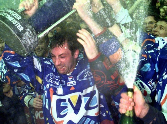 Der Zuger Kaptain Andre Roetheli hebt am Samstag, 11. April 1998, in Davos den ersten Meisterpokal der Zuger Eishockeyclub-Geschichte in die Hoehe. (Keystone/Michele Limina)