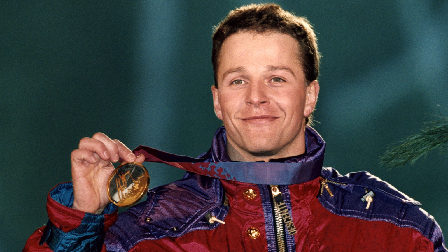 Stolz praesentiert der Schweizer Andreas &quot;Sonny&quot; Schoenbaechler seine Goldmedaille im Sprungwettbewerb der Skiakrobaten, aufgenommen am 24. Februar 1994 waehrend der Siegerehrung an den Olym ...
