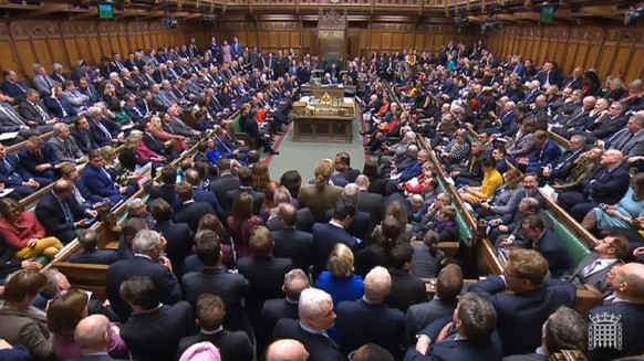 epa07432020 A grab from a handout video made available by the UK Parliamentary Recording Unit shows Members of Parliament after voting at the House of Commons parliament in London, Britain, 12 March 2 ...