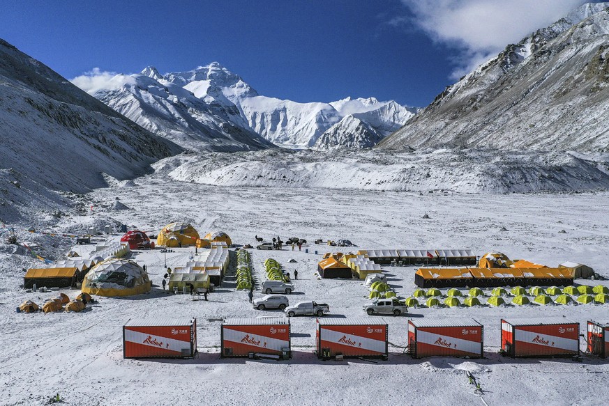 FILE - In this April 30, 2020, aerial file photo released by China&#039;s Xinhua News Agency, vehicles and tents are seen at the base camp at the foot of the Chinese side of the peak of Mount Qomolang ...