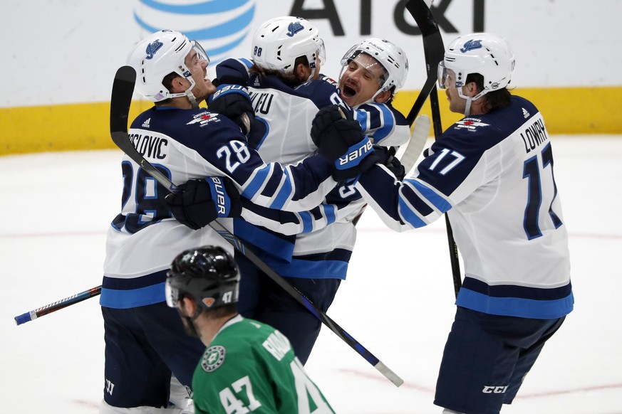 Dallas Stars right wing Alexander Radulov (47) skates past as Winnipeg Jets&#039; Jack Roslovic (28), Nathan Beaulieu (88), Luca Sbisa (5) and Adam Lowry (17) celebrate a goal by Sbisa in the third pe ...