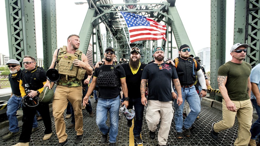 FILE - Members of the Proud Boys, including organizer Joe Biggs, third from right, march across the Hawthorne Bridge during an &quot;End Domestic Terrorism&quot; rally in Portland, Ore., on Saturday,  ...