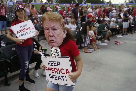 A young supporter of President Donald Trump wears a Trump mask during a campaign event with Ivanka Trump at Bayfront Park Amphitheater, Tuesday, Oct. 27, 2020, in Miami. (AP Photo/Wilfredo Lee)