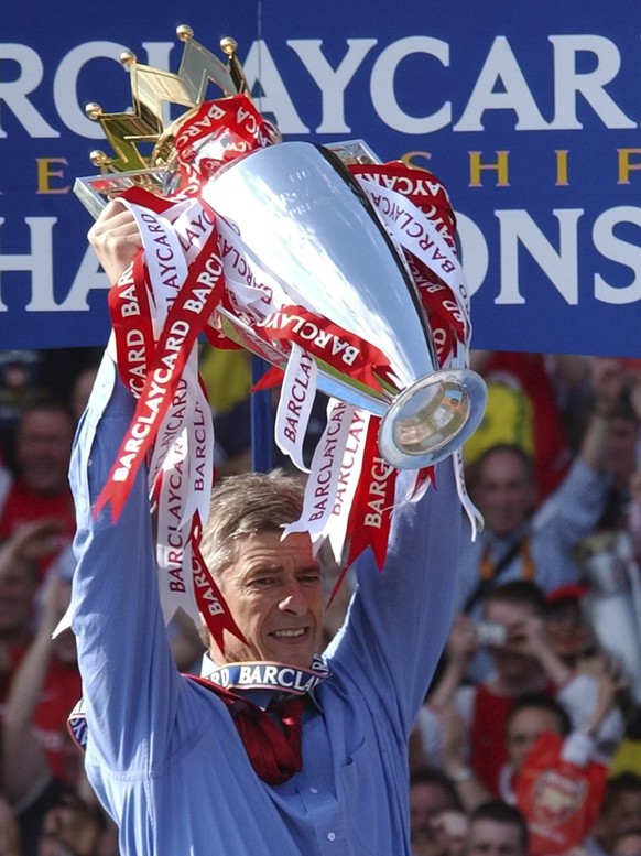 FILE - In this Saturday, May 15, 2004 file photo. Arsenal&#039;s manager, Arsene Wenger holds up the English Premiership Trophy for Arsenal winning the 2003/2004 season at Highbury, London. Wenger wil ...