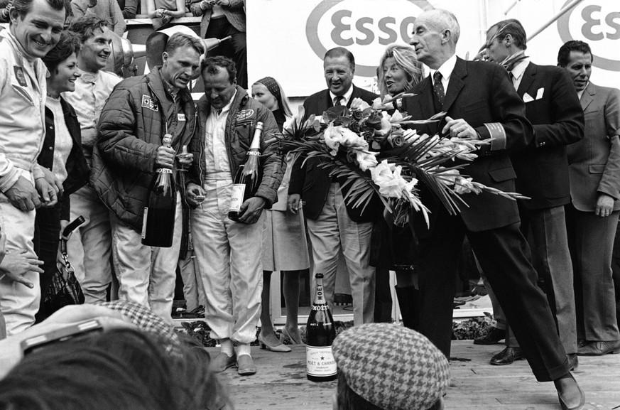 Henry Ford III and his wife Rurh, left, watch as driver Dan Gurney, left, of Costa Mesa, Calif., and A.J.Foyt, of Houston, Tex., second from left, have a chat June 11, 1967 at Le Mans, France, after w ...