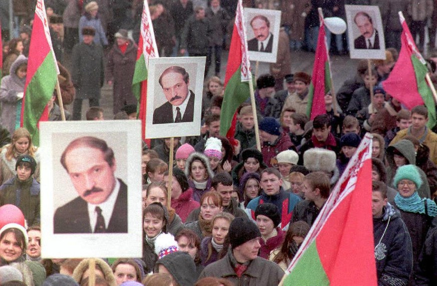 Pro-government supporters march in the streets of Minsk wioth portraits of Belarus President Aleksander Lukashenko, 22 November, to celebrate the first anniversary a referendum that gave Lukashenko al ...