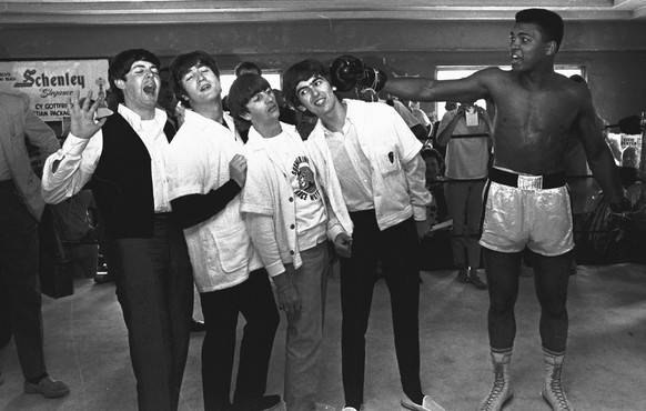 The Beatles, from left, Paul McCartney, John Lennon, Ringo Starr, and George Harrison, take a fake blow from Cassius Clay, who later changed his name to Muhammad Ali, while visiting the heavyweight co ...