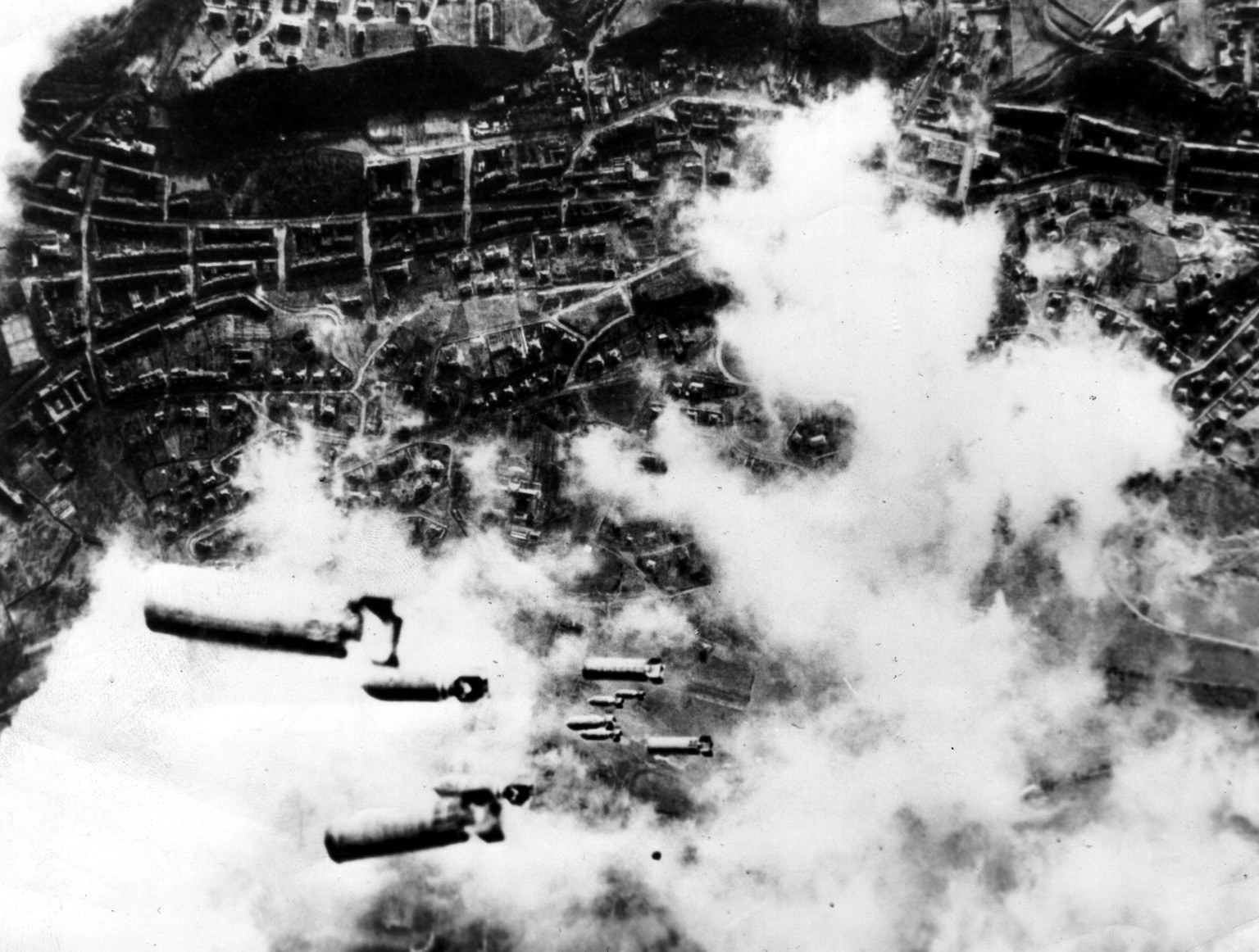 Heavy incendiary bombs, together with high exposives fall toward the city of Dresden (Germany), seen burning below as bombers of the 8th US Air Force attack the Saxony capital (February 14, 1945). (Ph ...