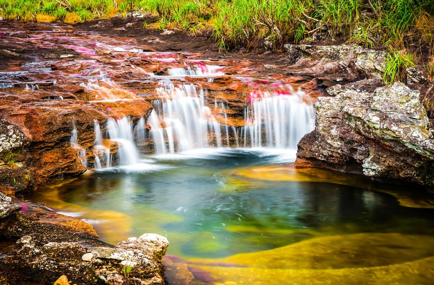 Der Caño Cristales ist ein Fluss in Kolumbien, der als flüssiger Wasserfall bekannt ist. Eine spezielle Algenart sorgt für Rottöne, die sich mit dem Blau des Wassers, dem Gelb des Sandes, dem Grün der ...