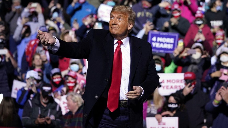 President Donald Trump throws face masks into the crowd during a campaign rally at John Murtha Johnstown-Cambria County Airport, Tuesday, Oct. 13, 2020, in Johnstown, Pa. (AP Photo/Evan Vucci)
Donald  ...